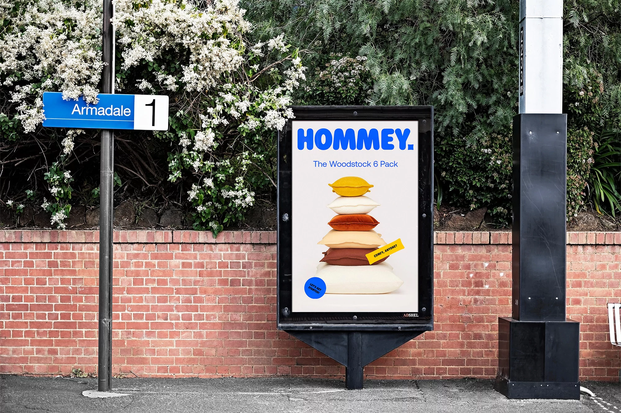 Outdoor advertising billboard featuring Hommey brand pillows stacked against a brick wall and greenery in Armadale, Victoria, Australia.