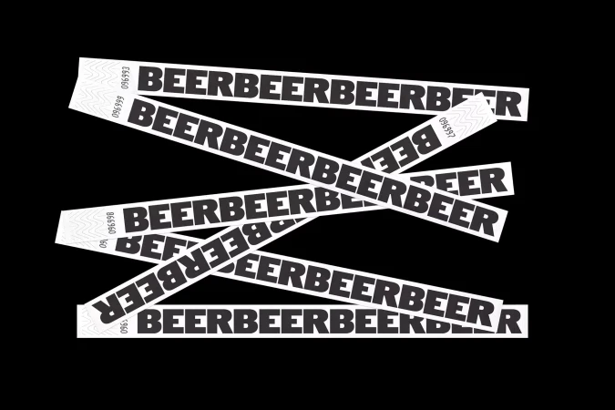 Graphic design featuring a repeating black 'BEER' text pattern on white adhesive labels, diagonally layered against a solid black background.