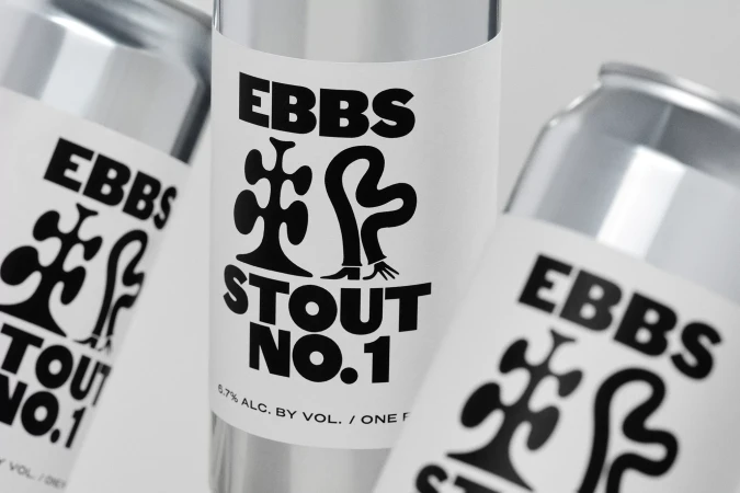 Three silver beer cans with white labels, featuring a black graphic logo and the text 'EBBS Stout No. 1', against a neutral background.