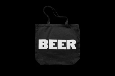 Black canvas tote bag featuring large white block text reading BEER against a solid black background.