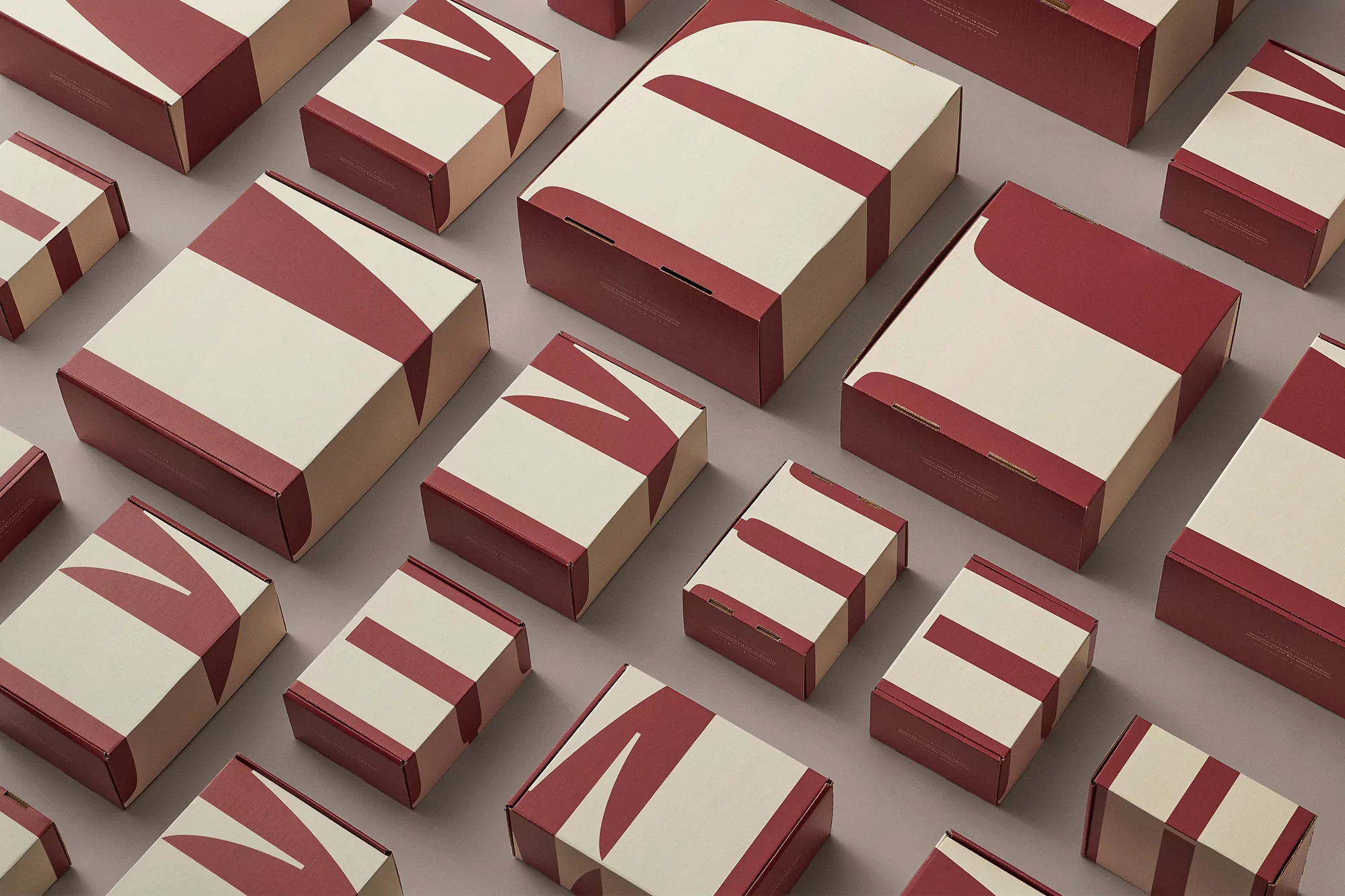 Overhead shot of multiple patterned boxes in a grid arrangement featuring a minimalist design with cream and maroon colors.