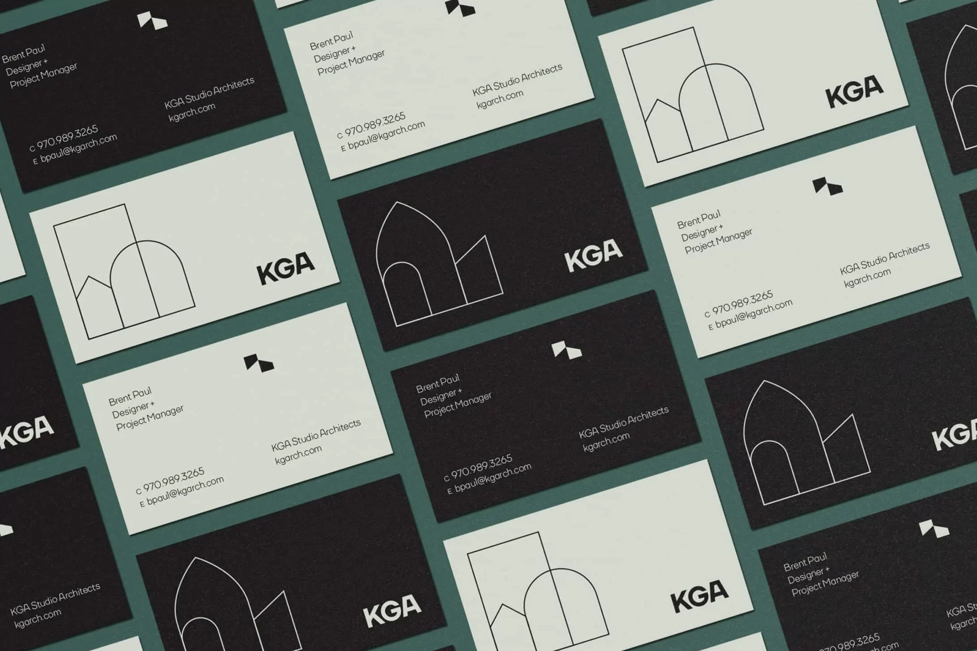 Collection of black and light-colored business cards with the KGA Studio Architects logo arranged on a dark green background.