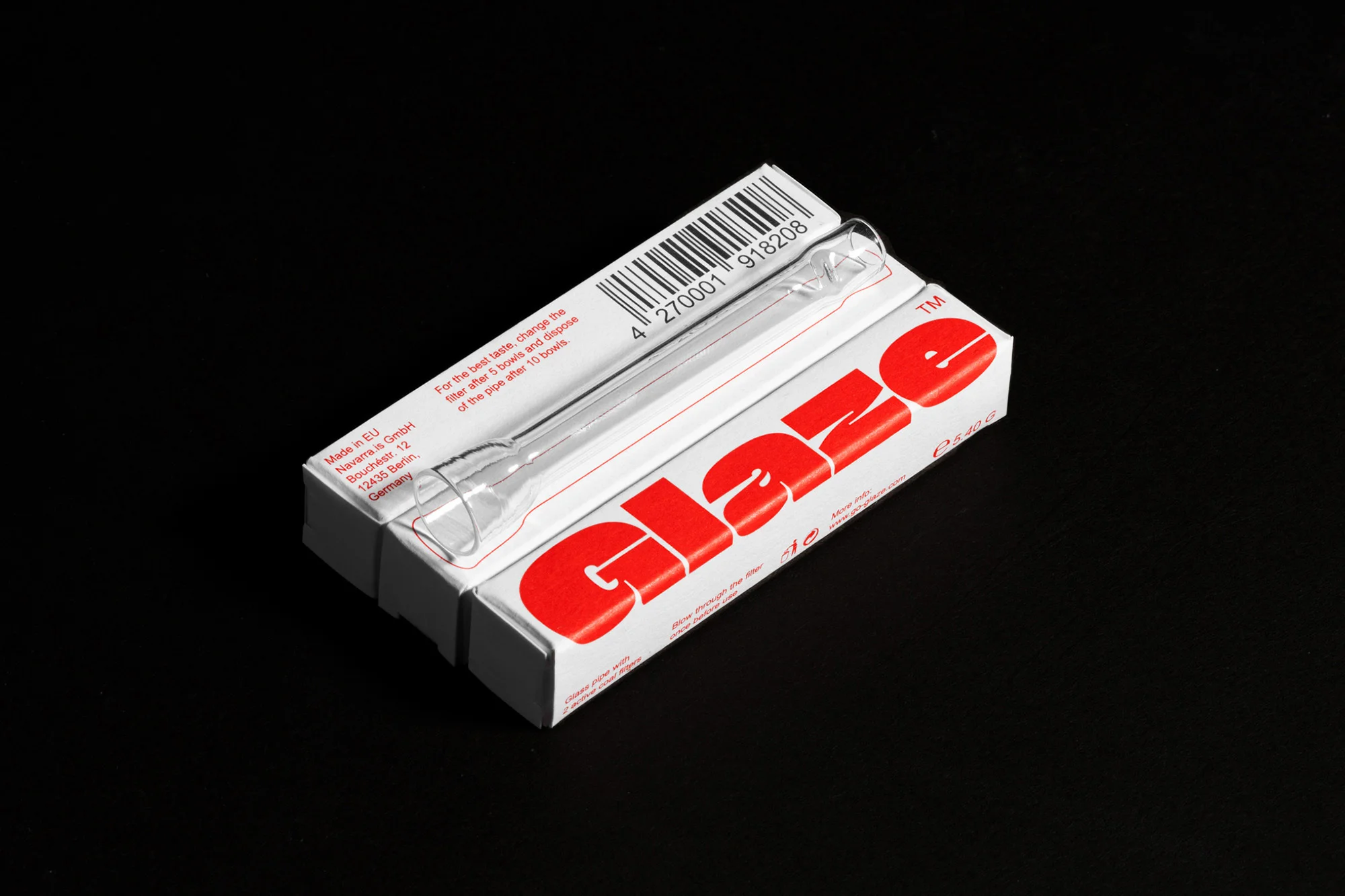A glass pipe rests on a Glaze-branded box against a black background. The box features red lettering and a barcode on top.