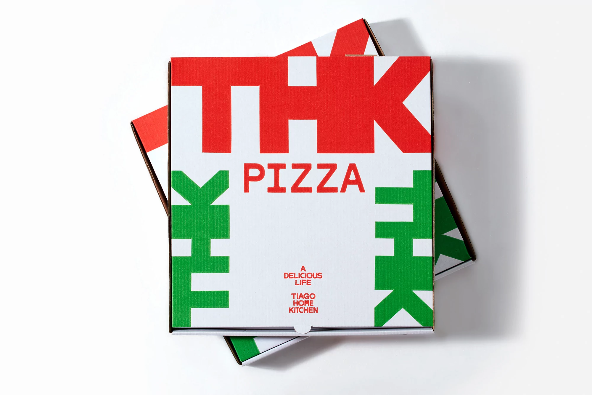 Two stacked white pizza boxes with 'THK PIZZA' in red and green block letters, top-down view on white background with soft shadows.