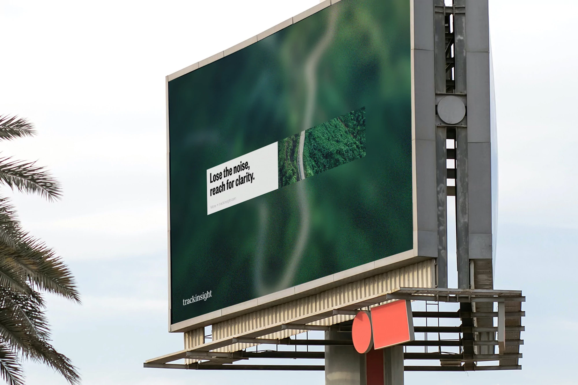 Billboard advertisement displays blurred green landscape with text reading, 'Lose the noise, reach for clarity' against a cloudy sky.