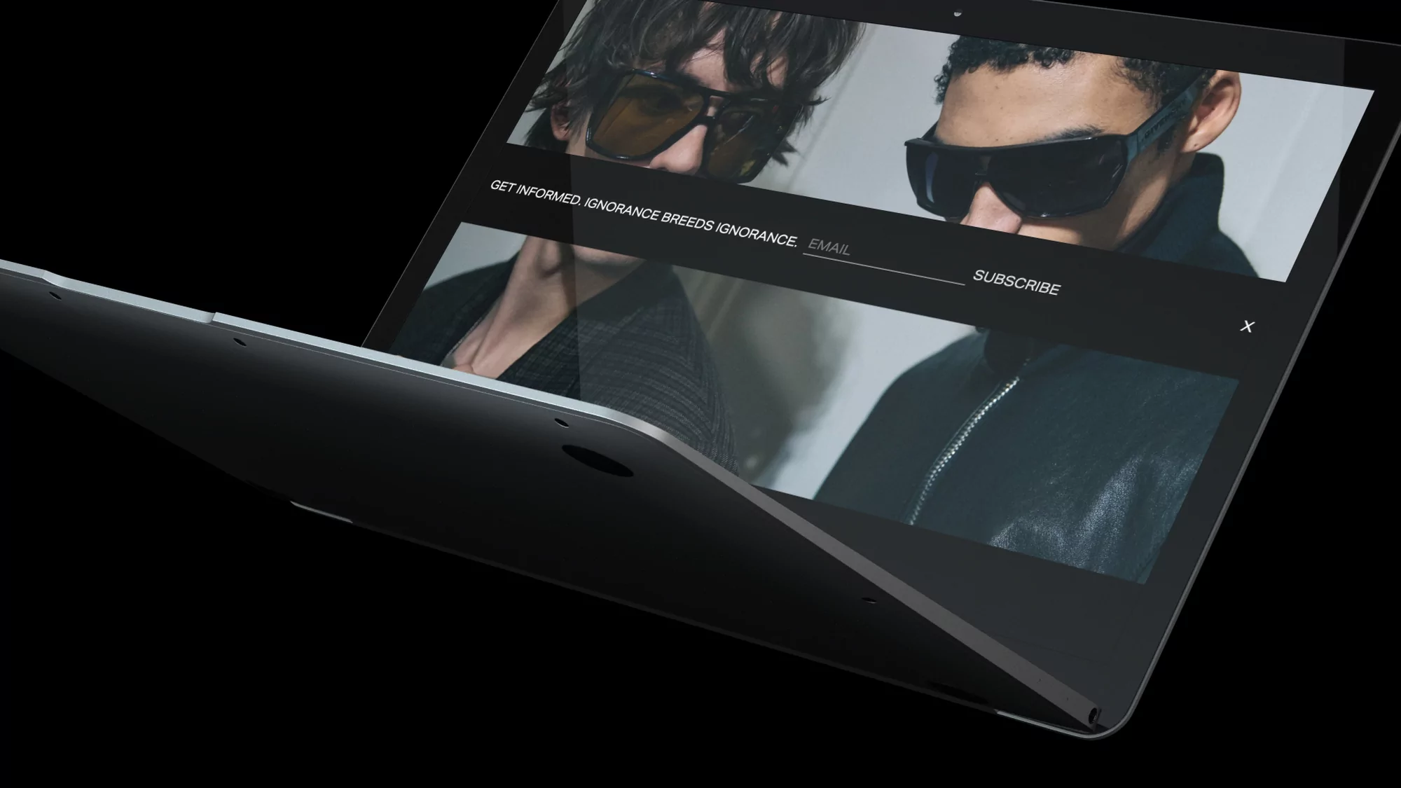 Silver laptop displays two adult males wearing sunglasses and jackets against a black background, fashion, and technology.