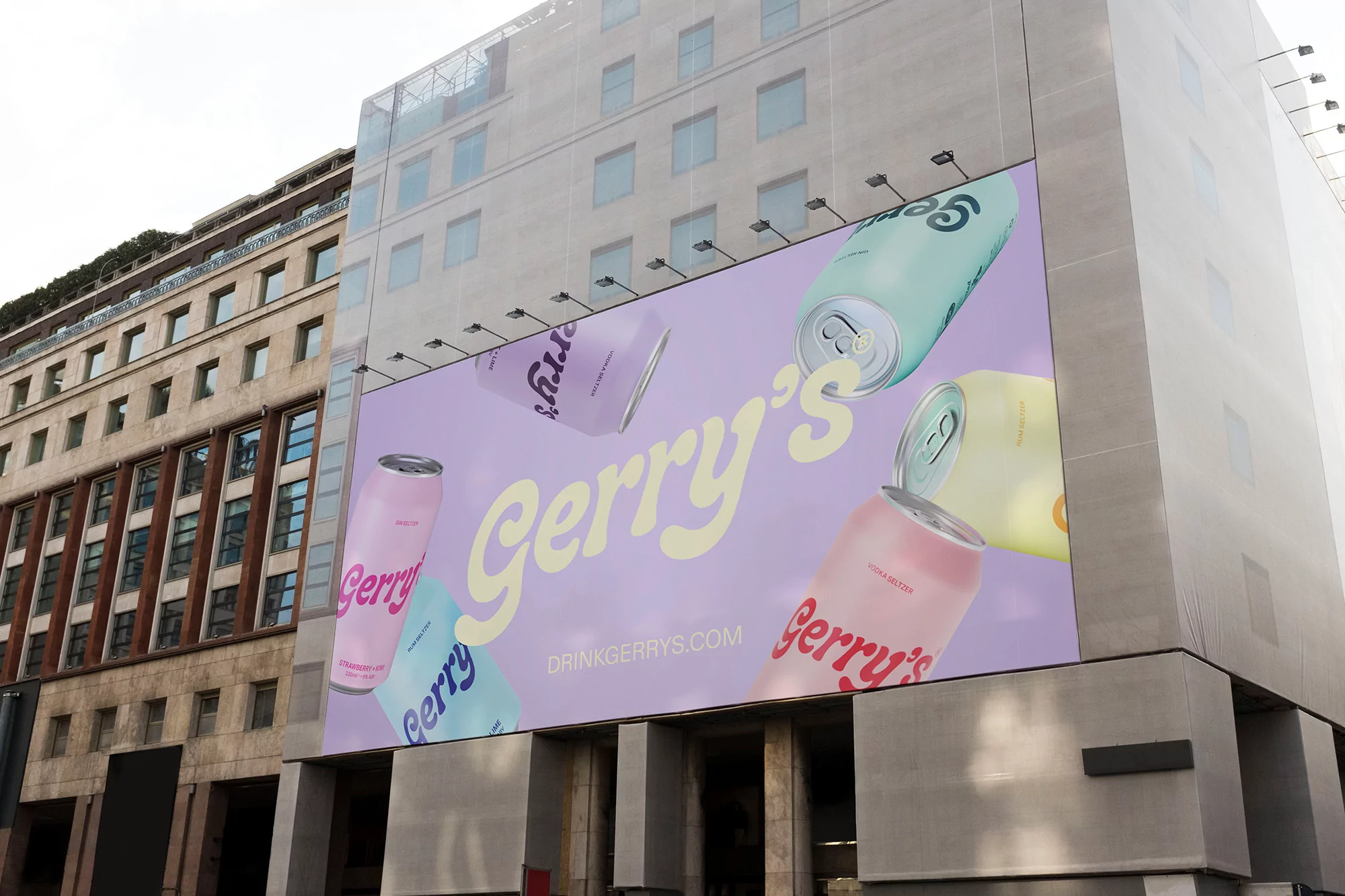 Outdoor advertisement featuring colorful Gerry's canned beverages on a building, promoting drinkgerrys.com, set against a city backdrop.