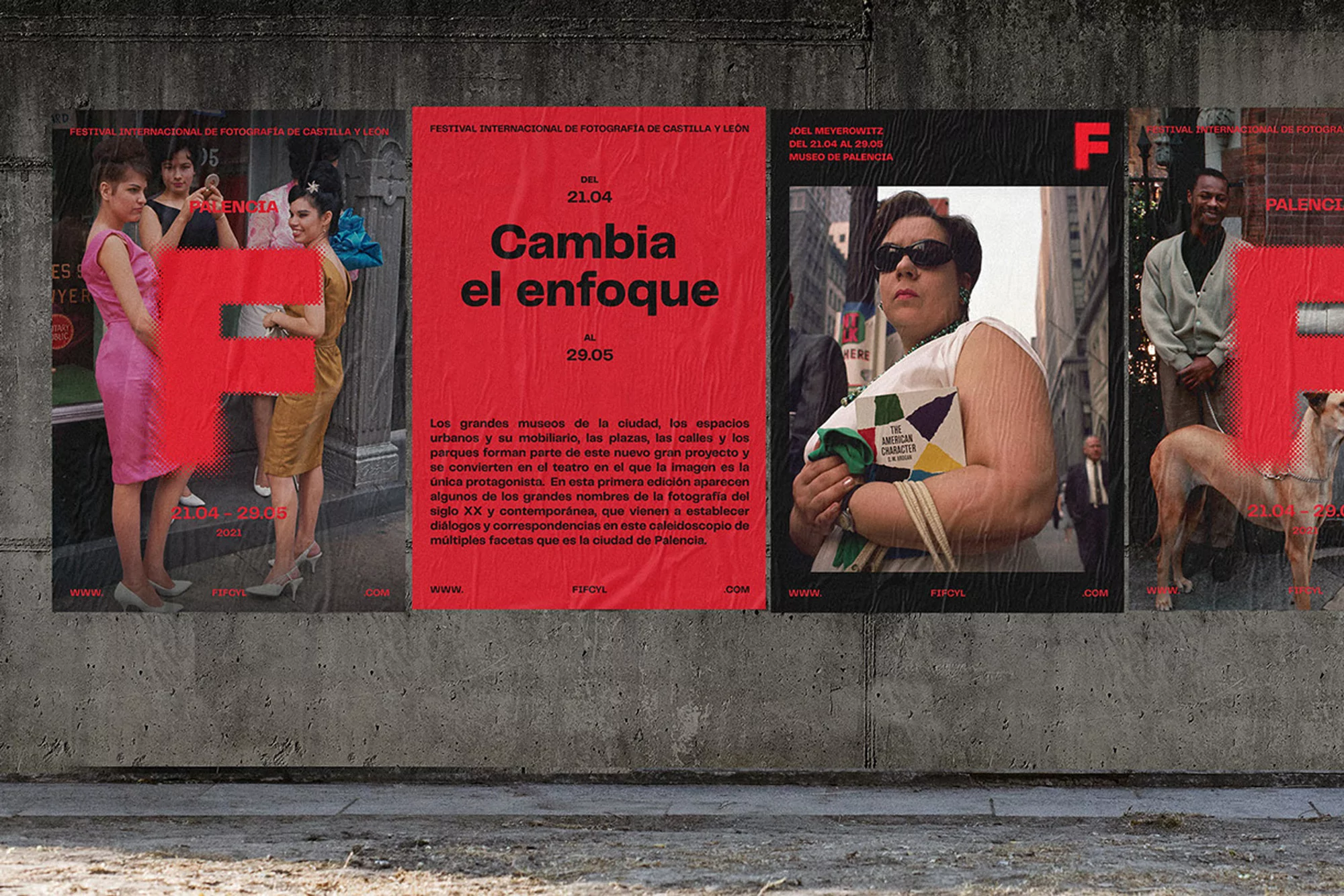 Outdoor view of a weathered concrete wall featuring a series of international photography festival posters. Street-level perspective.