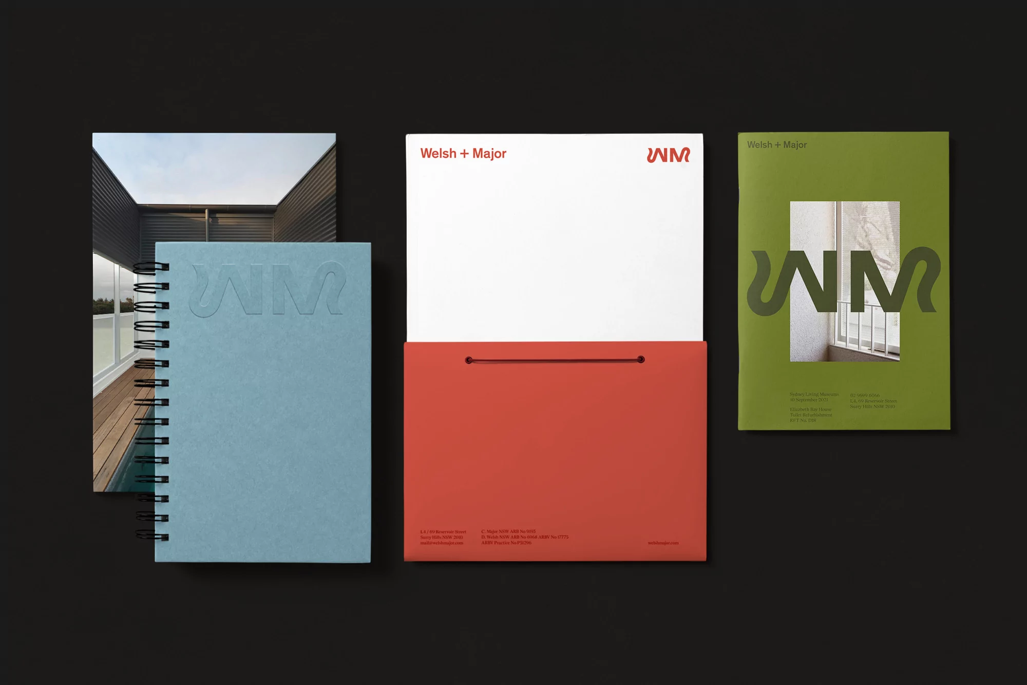 Three print marketing materials are arranged on a black surface: a notebook, a brochure, and a pocket folder.