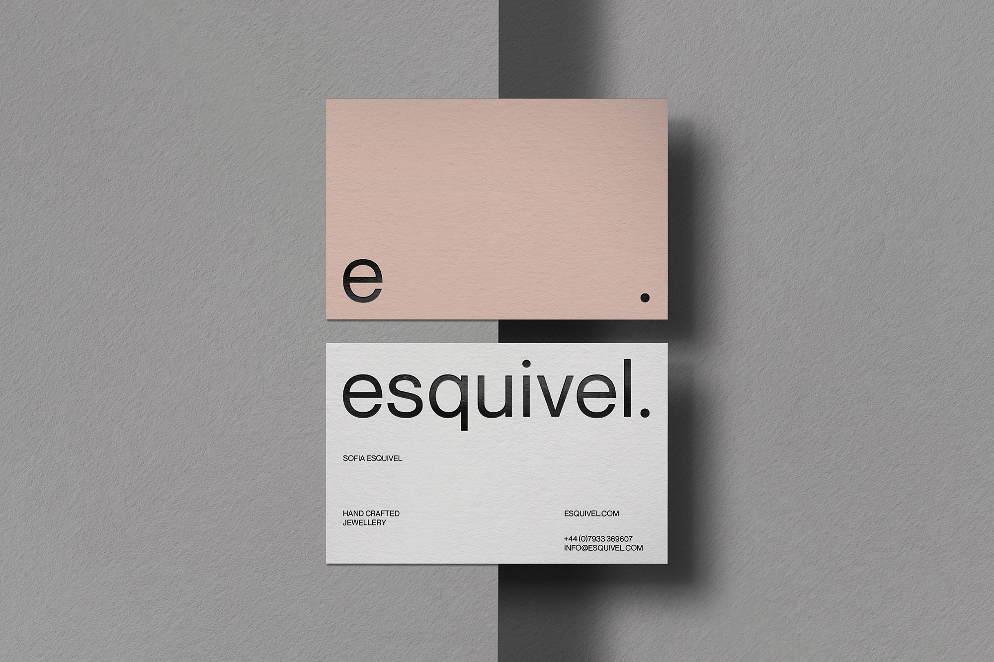 Two business cards, one light peach with a lowercase 'e' and a dot, and one white with 'esquivel.' in black sans-serif typeface.