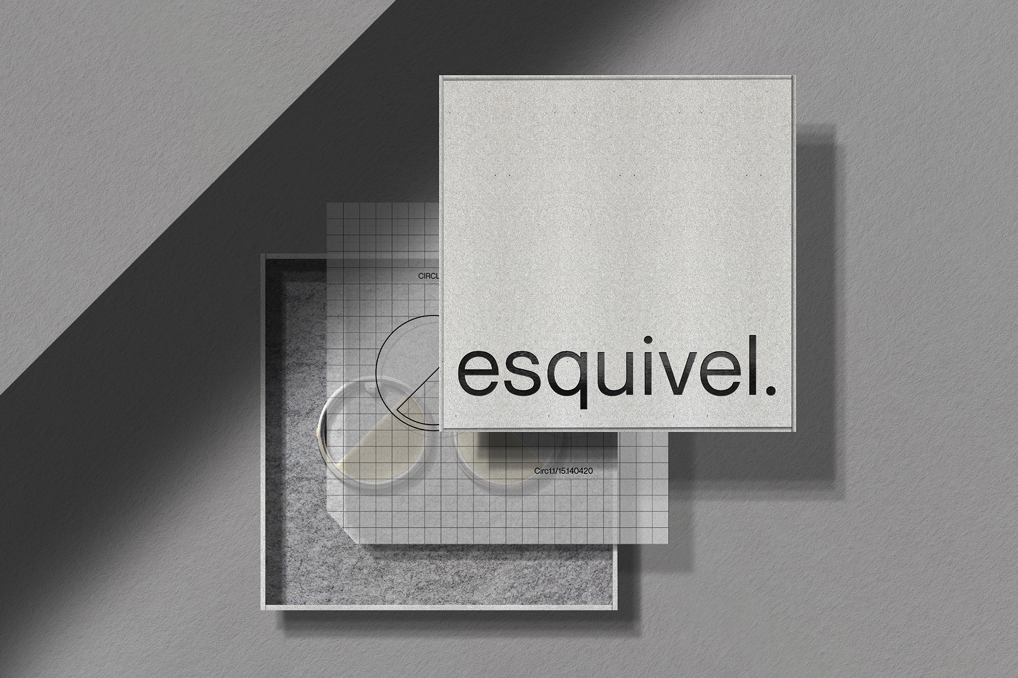 Elevated view of a box packaging mockup, showcasing a square product box with the brand name 'esquivel.' and a grid patterned insert.