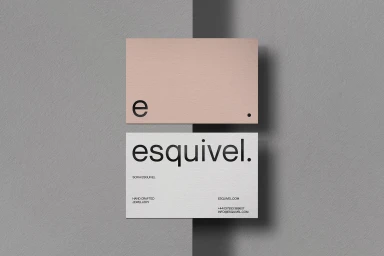 Two business cards with minimal typography displayed on a textured grey background surface