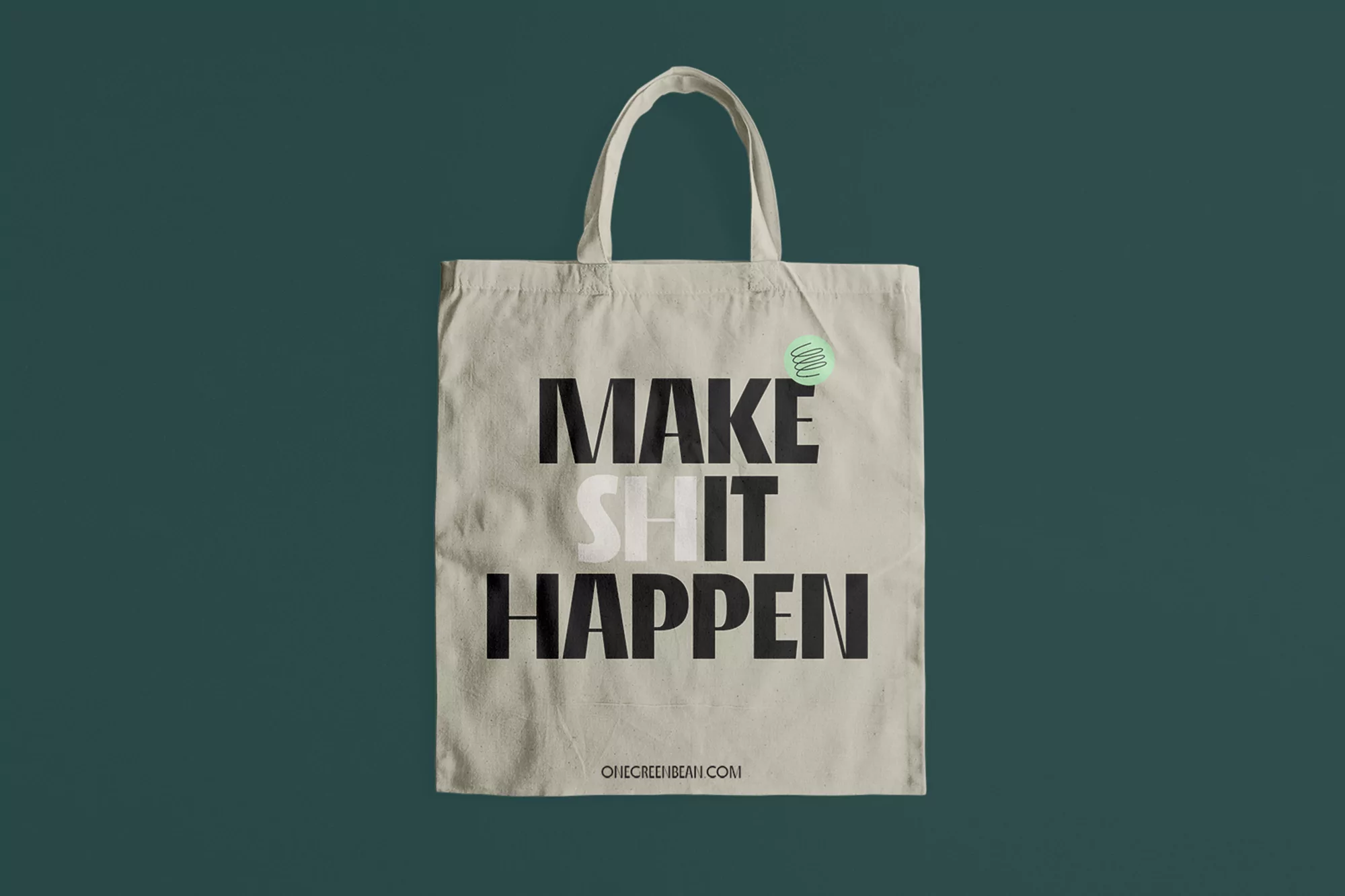 Off-white canvas tote bag with bold black typographic text against a dark green solid background.