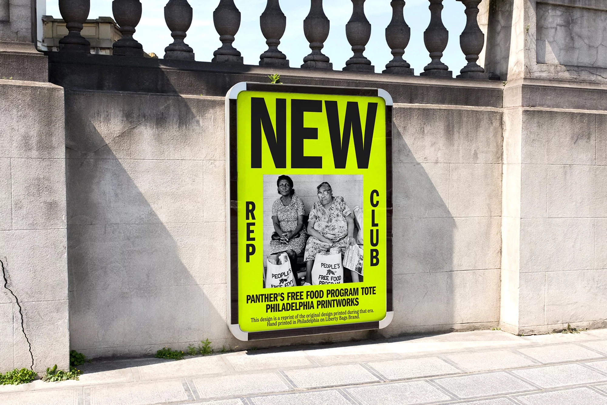 Poster adhered to a stone wall features a black and white photograph of two elder women with tote bags, promoting a food program.
