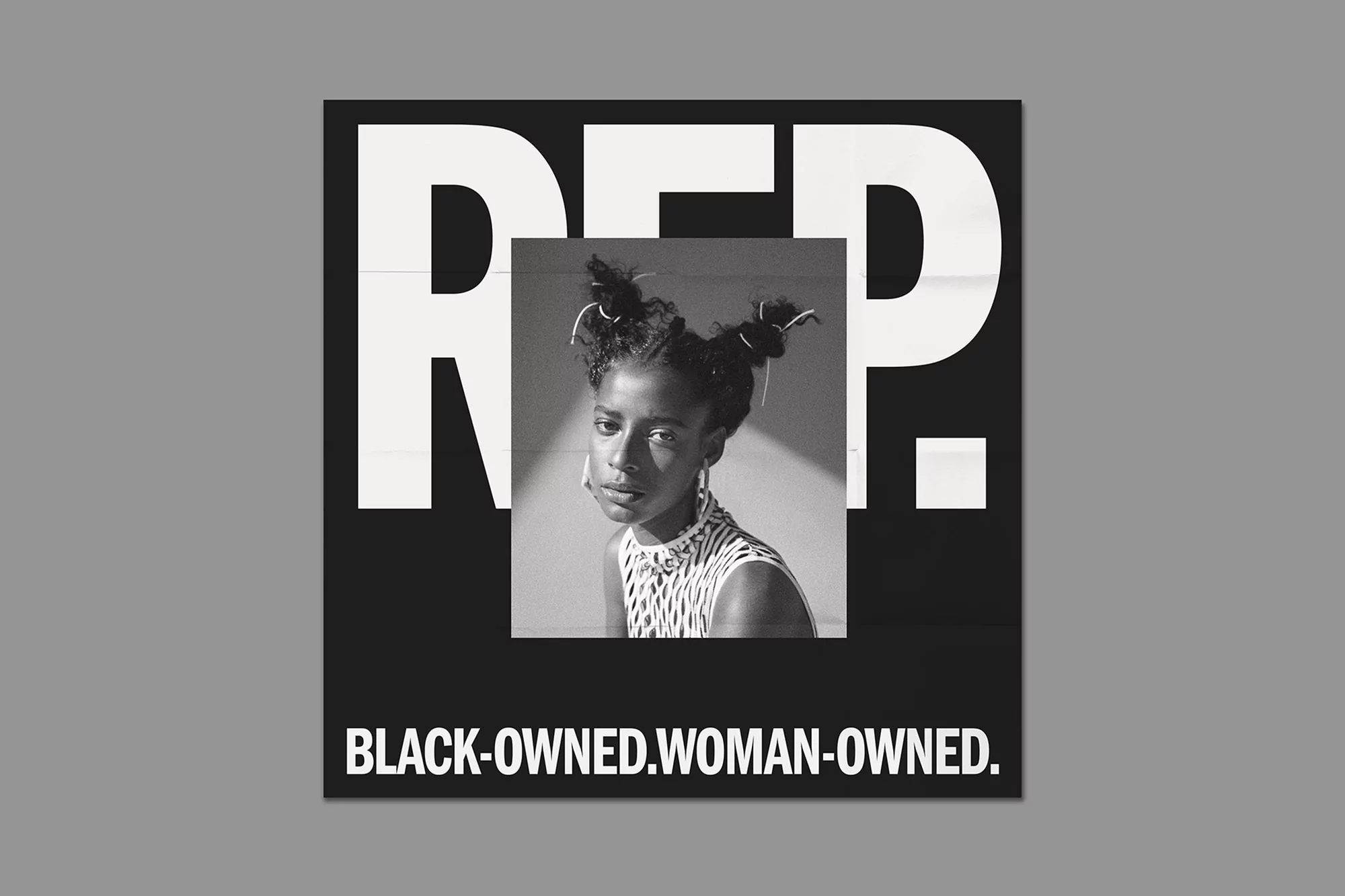Black and white studio shot of a Black woman with hair buns, accessorized with earrings, against a bold typographic backdrop.