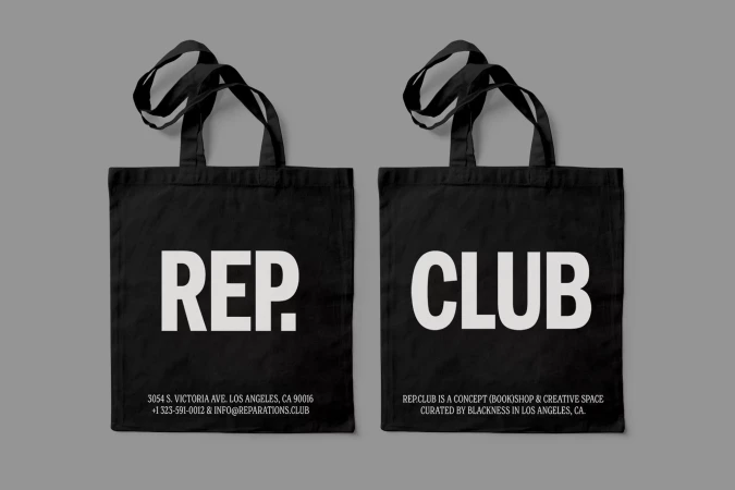 Two black tote bags with bold white typography reading REP and CLUB displayed against a neutral grey background
