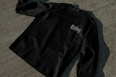 Black long-sleeve pocket t-shirt with Cadre logo on pavement background