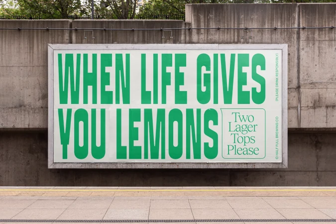 Eye-level shot of an advertising billboard featuring a green and white design with the text 'WHEN LIFE GIVES YOU LEMONS'.