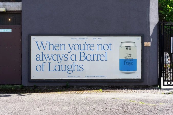 Outdoor advertising for Half Full Brewing Co. features a can of beer against a blue wall with a slogan and brand details.