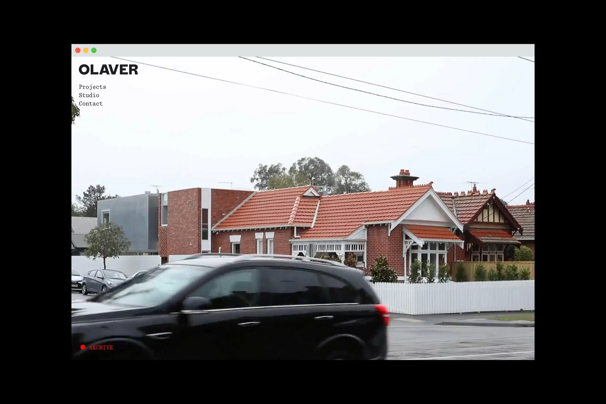 View of OLAVER website featuring modern and traditional house exteriors, set against a cloudy sky, showcasing architectural design.
