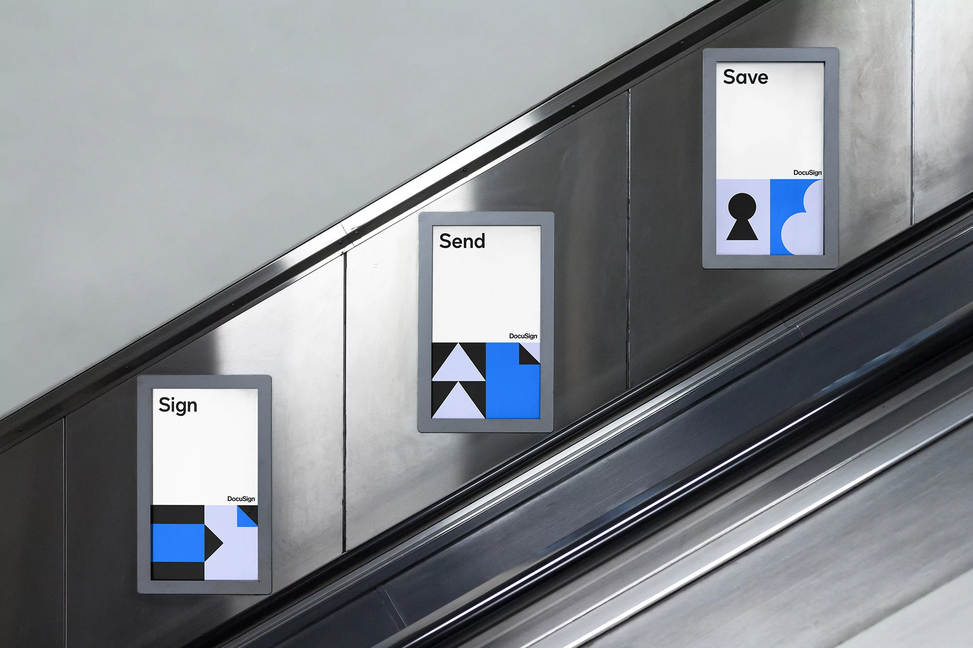 Three DocuSign posters aligned along a gray escalator, displaying 'Sign', 'Send', and 'Save' messages with geometric designs.