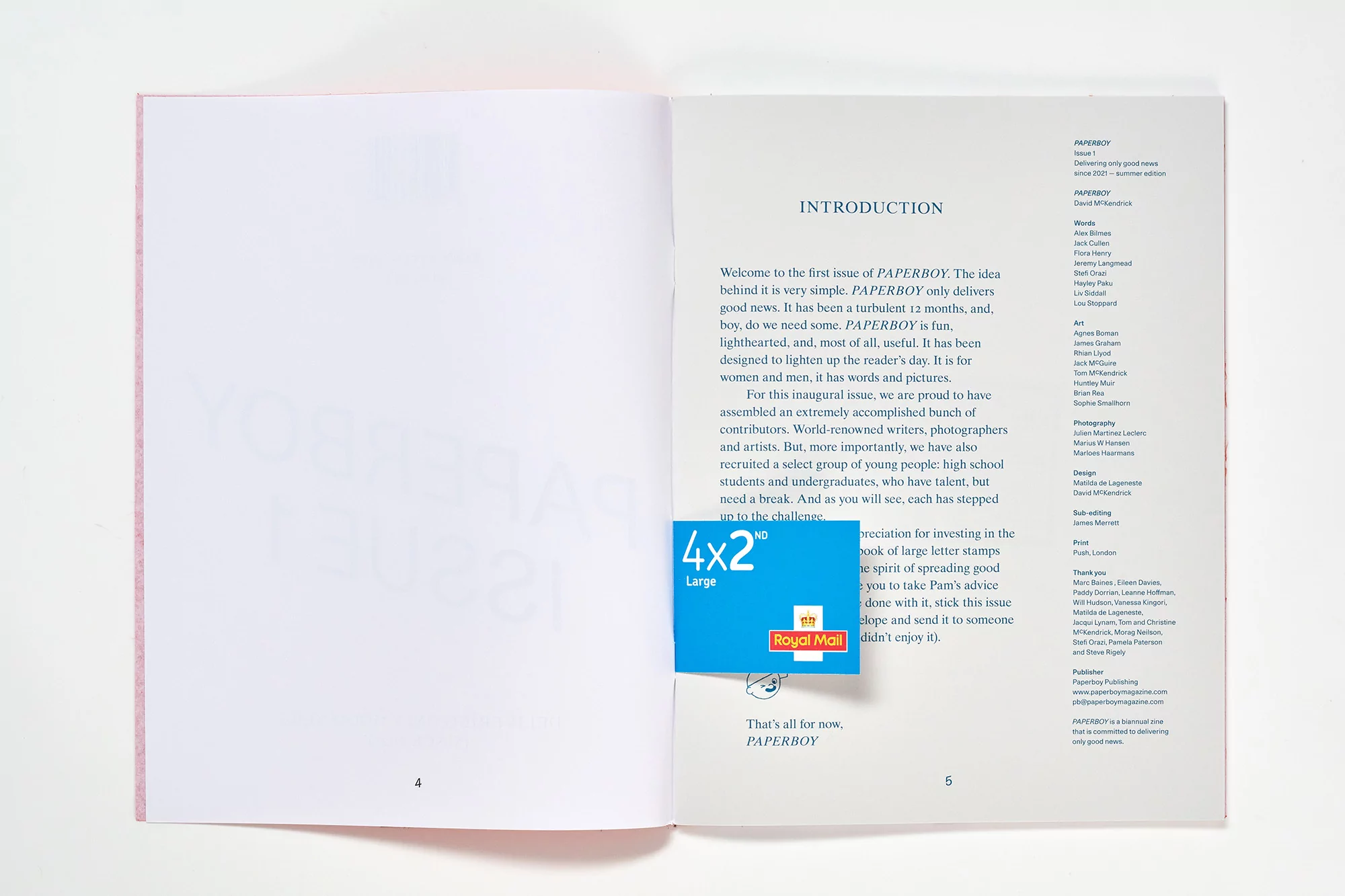 Open pages of a 'Paperboy' magazine displaying the introduction and a blue Royal Mail stamp. The magazine is on a white surface.