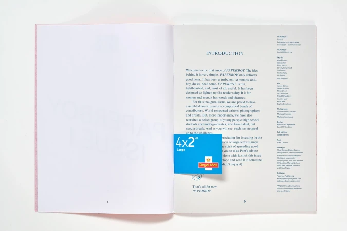 Open pages of a 'Paperboy' magazine displaying the introduction and a blue Royal Mail stamp. The magazine is on a white surface.