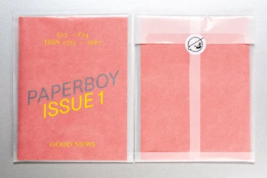 Front and back cover of Paperboy Issue 1 magazine inside a translucent protective plastic sleeve on a silver background.