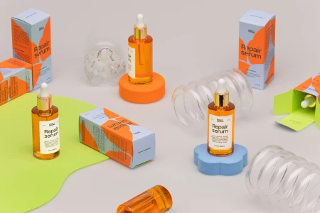 Pauli and Sisters Repair serum bottles and colourful packaging arranged on a neutral grey background with shapes