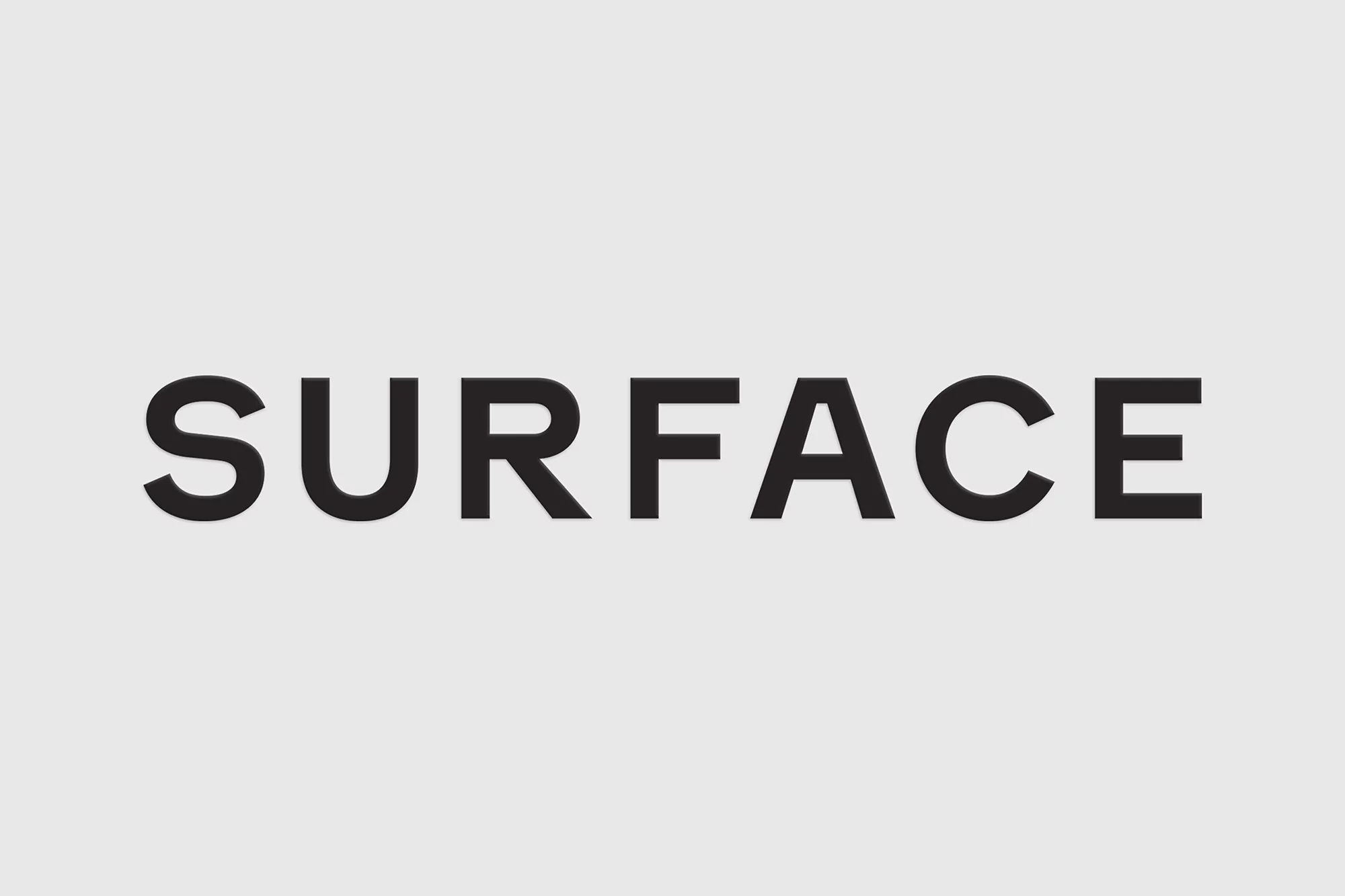The word 'SURFACE' displayed in large, bold, black font against a light gray background. Simple typography graphic.