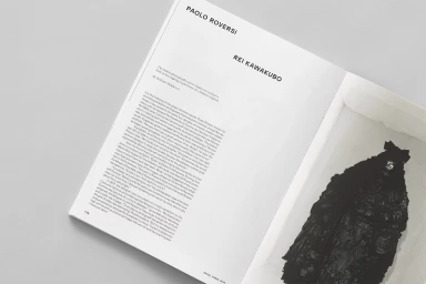 Open magazine pages featuring articles on Paolo Roversi and Rei Kawakubo with typography and a fashion photograph