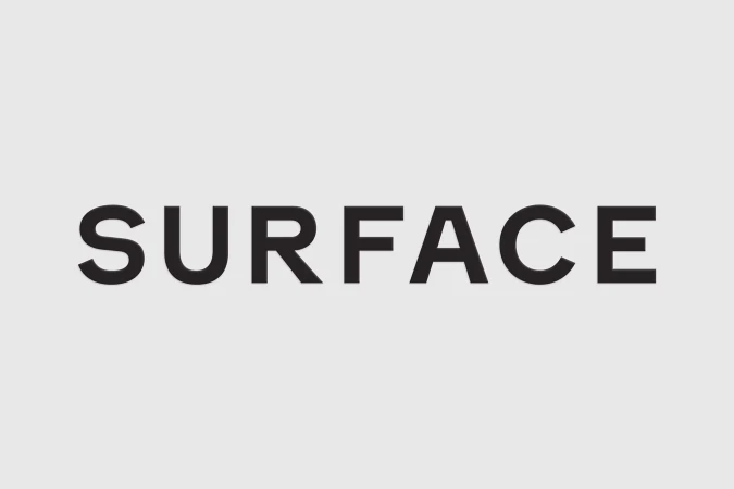 Black uppercase typography spelling SURFACE centered on a plain light grey background