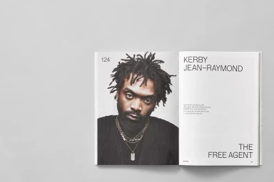 Open magazine spread featuring a portrait of Kerby Jean-Raymond on a grey surface for Surface Magazine brand identity.
