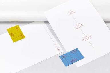Branding materials including printed paper sheets and business cards with red typography on white and coloured backgrounds