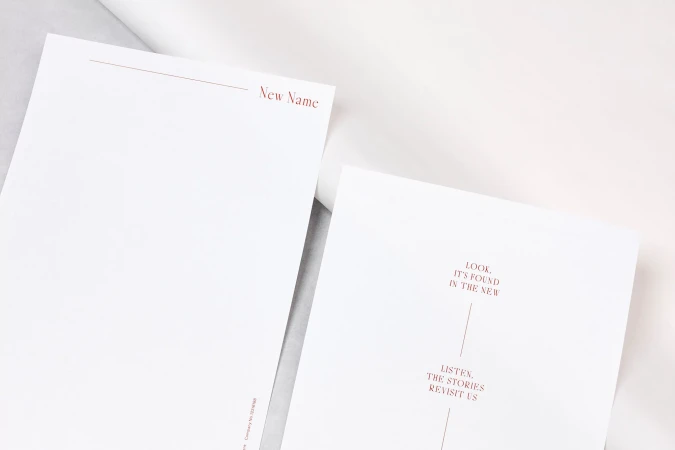 Letterhead and stationery featuring red typography reading New Name arranged on a light background surface