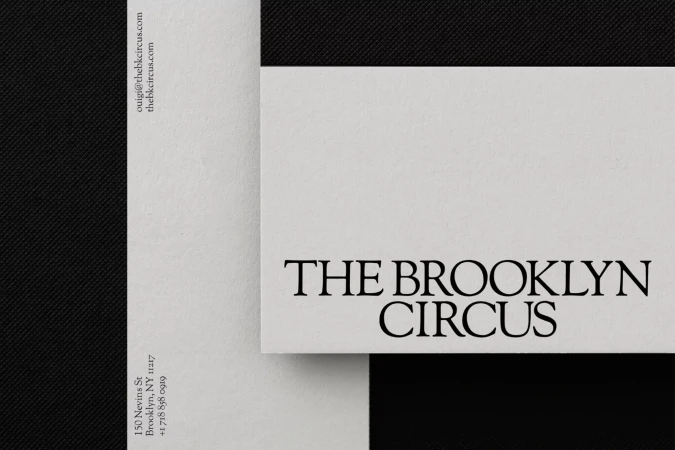 Minimalist business card design with white and black contrast, featuring the text 'THE BROOKLYN CIRCUS' and contact information.