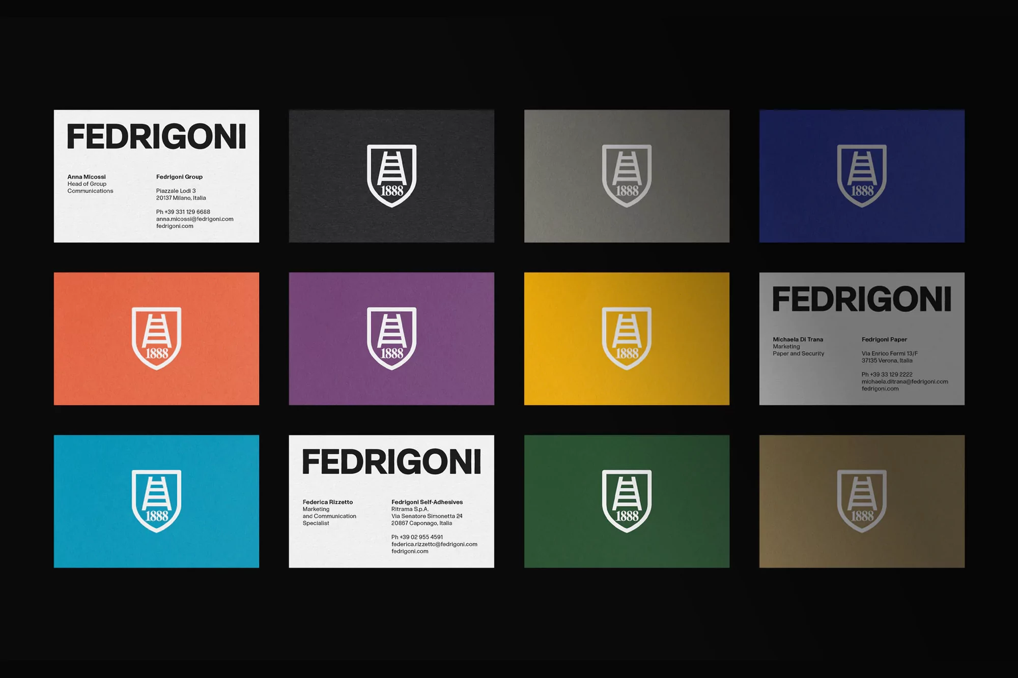 Collection of Fedrigoni business cards in various colors, featuring the brand's logo and contact information against a dark background.