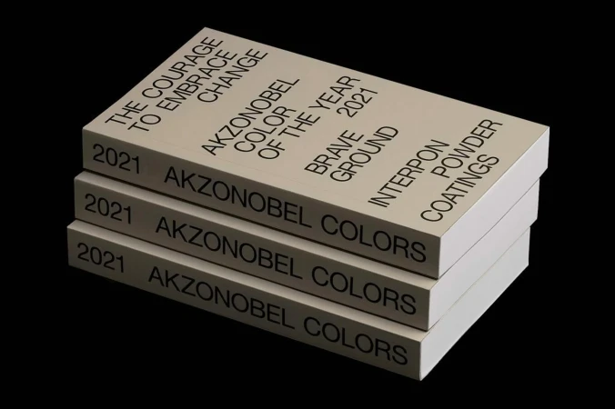 Stack of three Akzonobel Colors of the Year 2021 books on a black background, featuring 'Brave Ground' and 'Interpon Powder Coatings'.