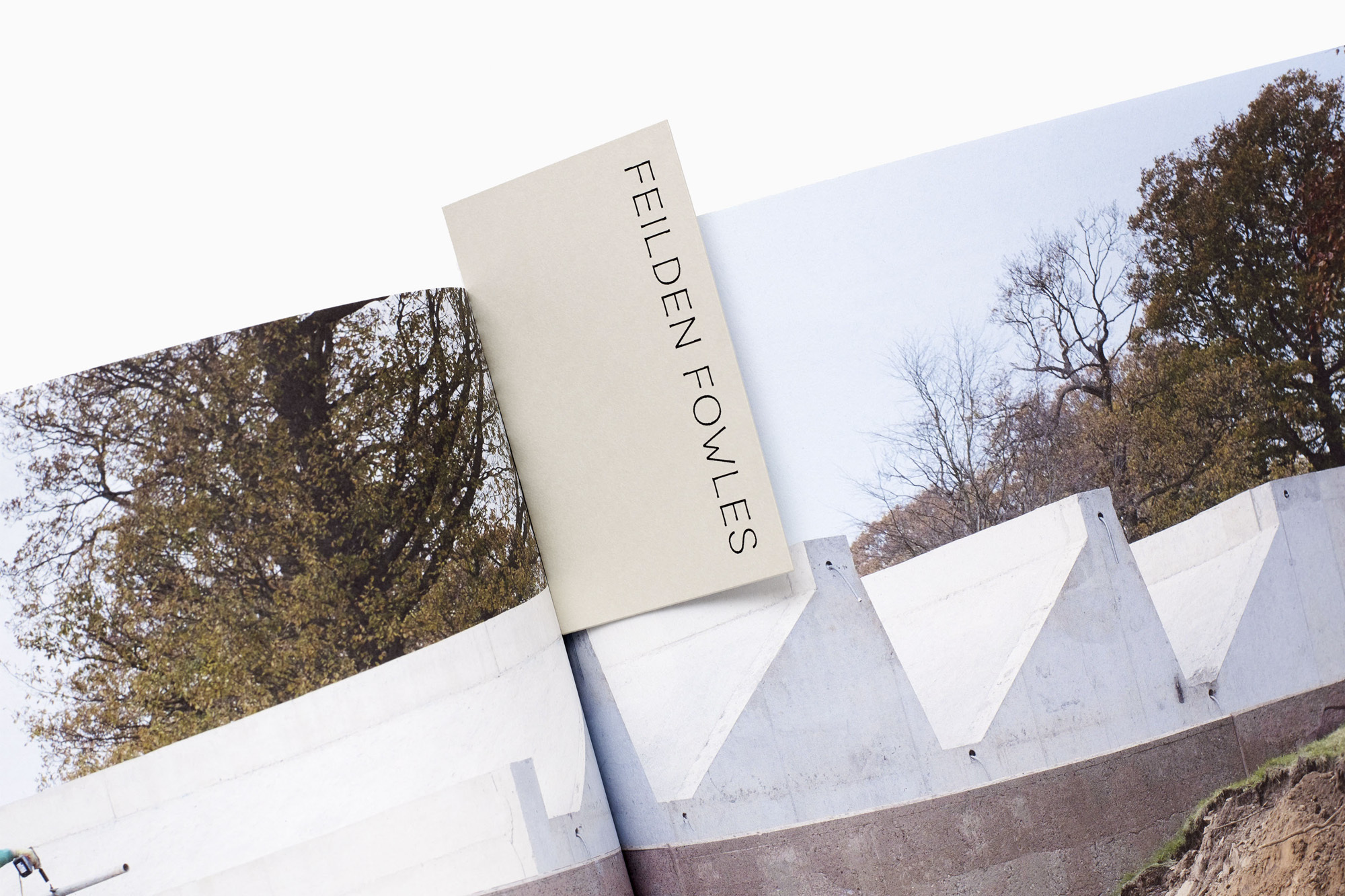 Open architecture book featuring Feilden Fowles, set against a bright background, showcases architectural design and landscape elements.
