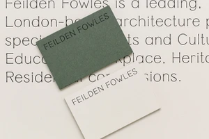 Two business cards with Feilden Fowles branding placed on a printed paper background.