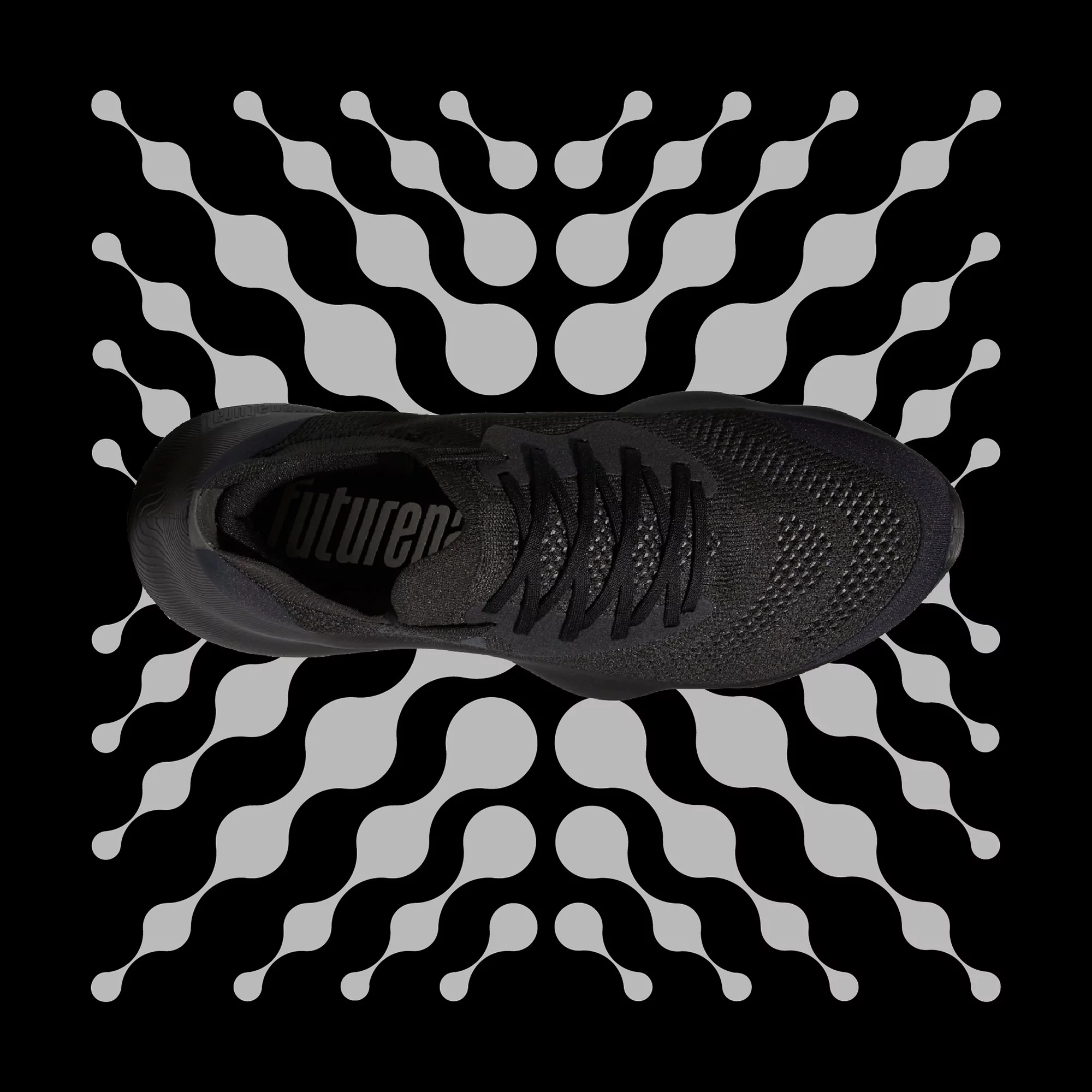 Elevated shot of a black athletic shoe atop a geometric black and gray patterned background, suitable for fitness advertising.