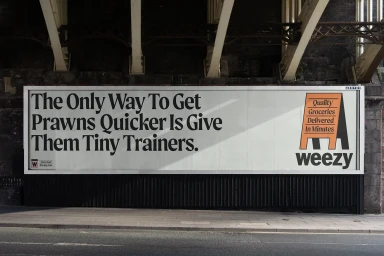 A Weezy advertising billboard featuring bold typography on a white background mounted beneath an overpass.
