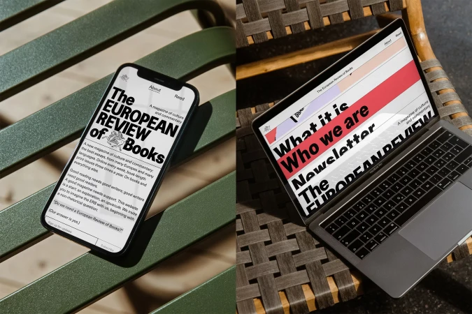 A smartphone and laptop displaying the website for The European Review of Books resting on outdoor slatted furniture.