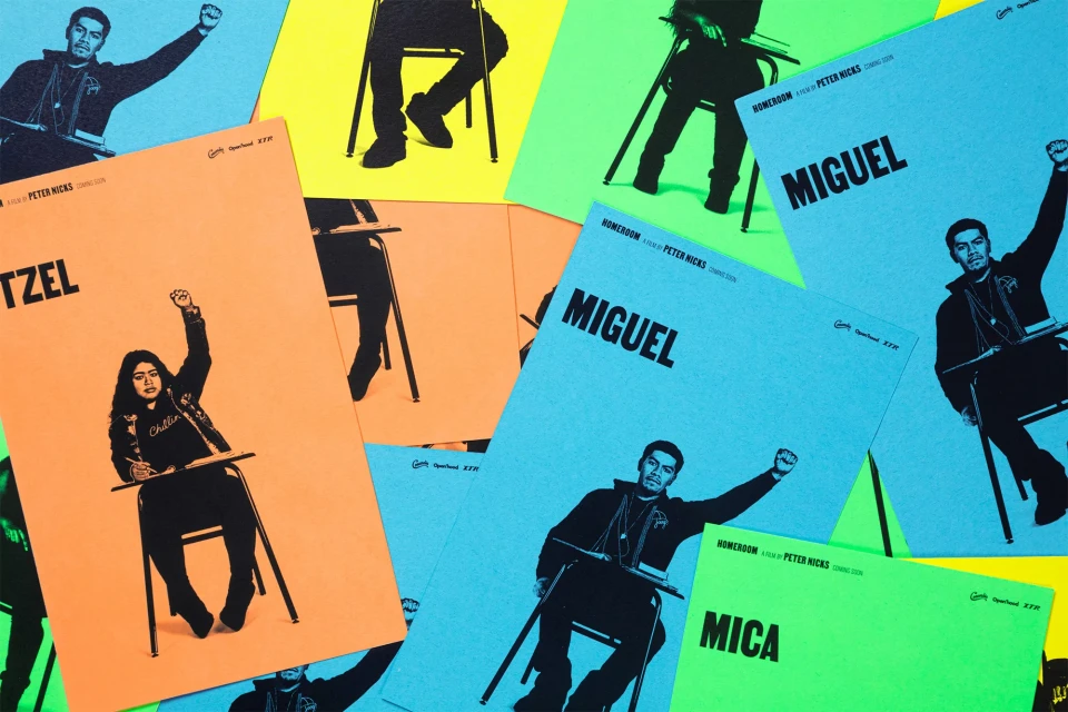 Movie posters featuring stylized images of students sitting at desks with raised fists, set against bright backgrounds of yellow, orange, and blue.