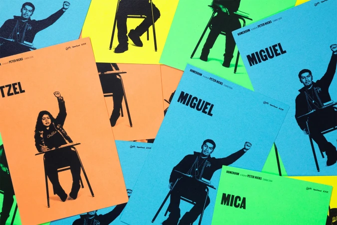 Movie posters featuring stylized images of students sitting at desks with raised fists, set against bright backgrounds of yellow, orange, and blue.
