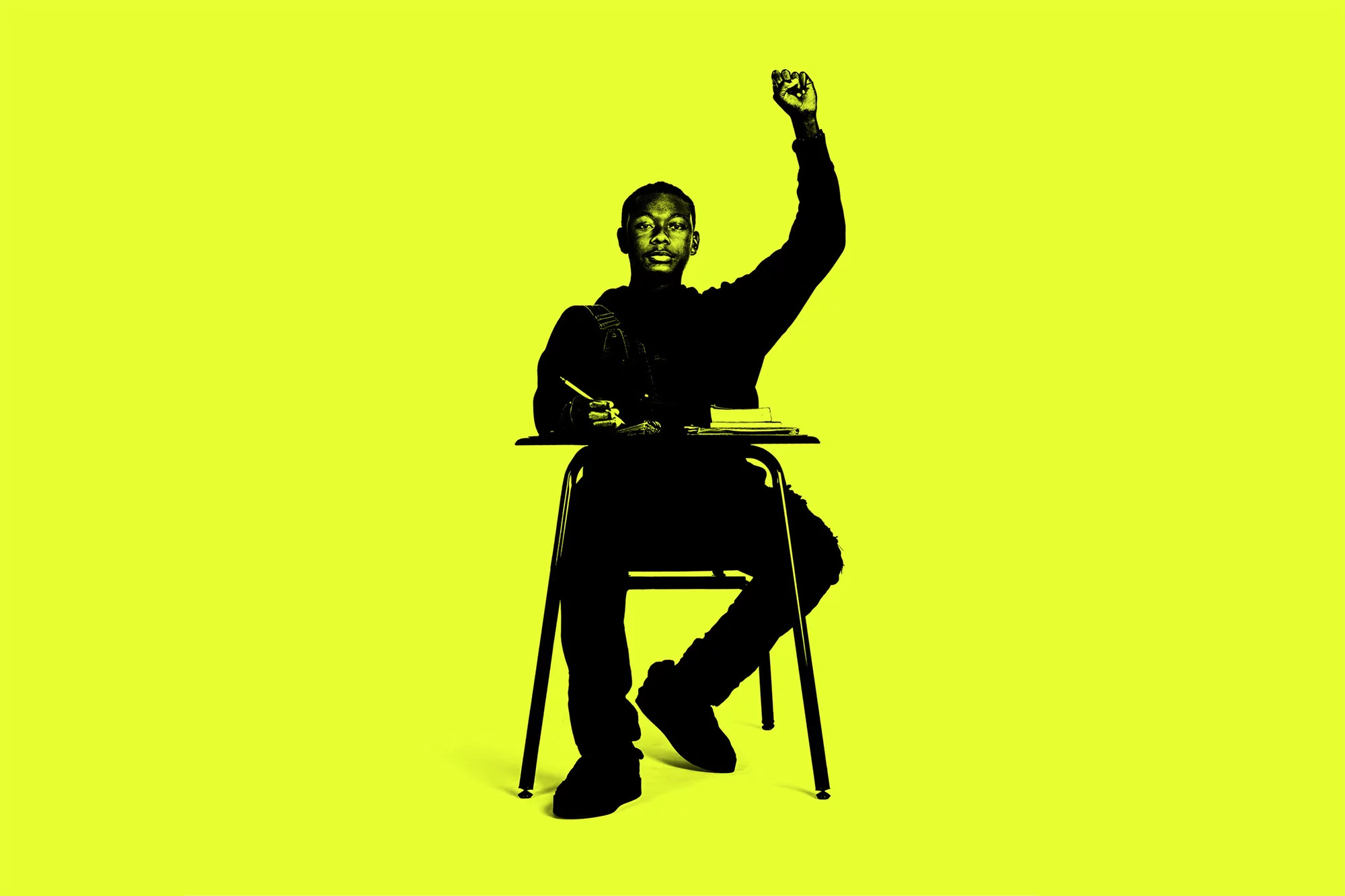 Silhouette of student sitting at desk with raised fist on yellow background. Person writing, classroom chair and desk.