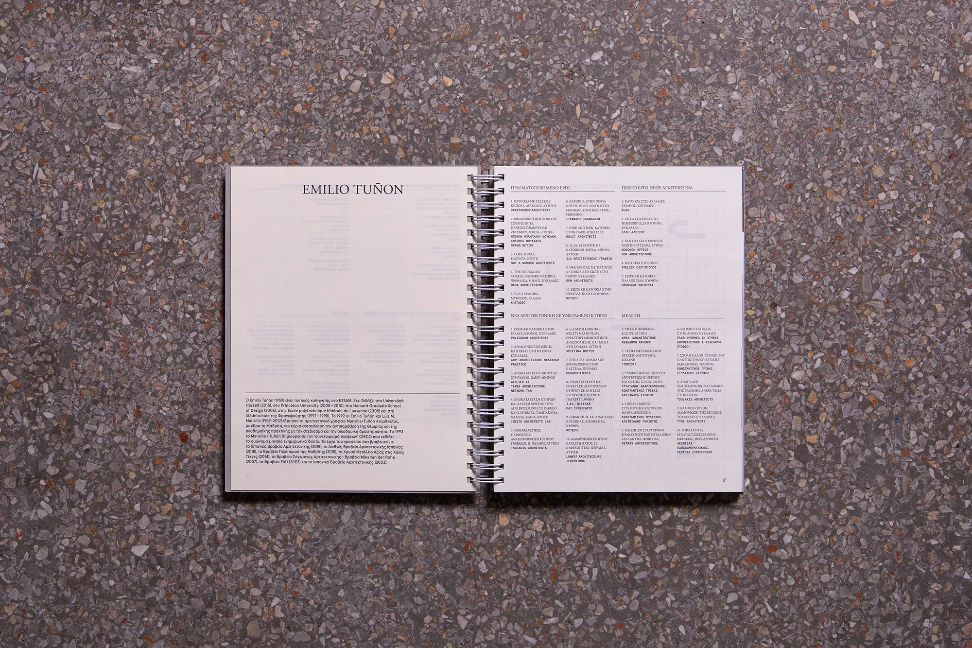 Open book featuring columns of text and a title, laying on a speckled surface, showcasing an editorial layout and architectural content.