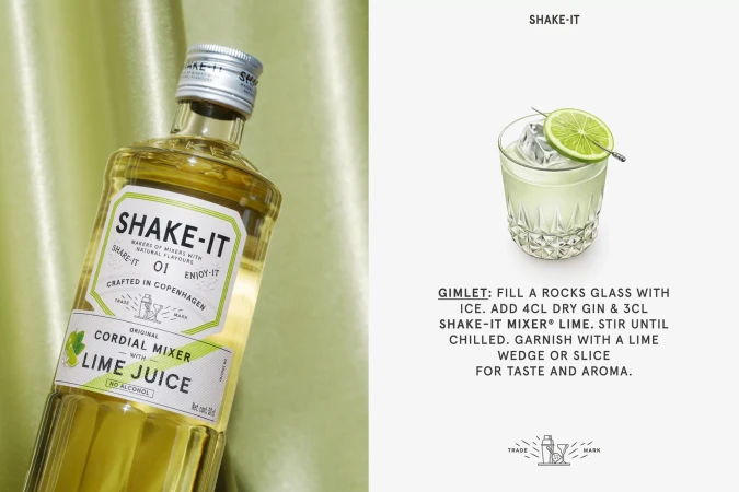 Bottle of Shake-It lime cordial mixer against a draped green satin background next to a recipe graphic for a gimlet cocktail