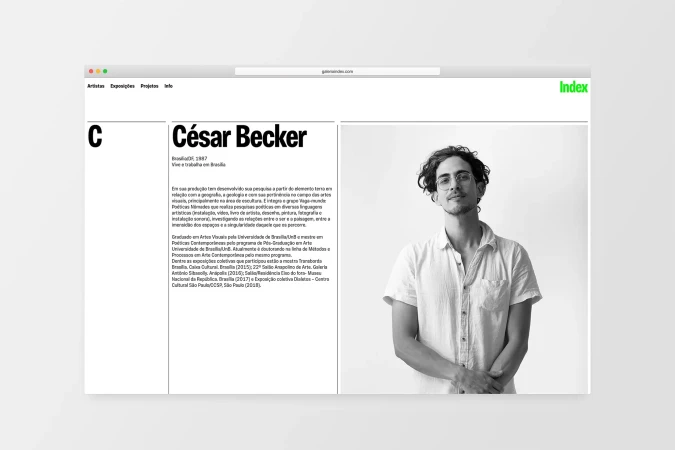 Black and white portrait on a website featuring a man with curly hair, wearing glasses and a button-down shirt, posing indoors.
