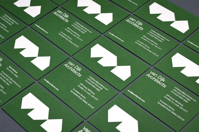 Close-up of multiple green business cards with a modern white geometric logo and architect contact information laid out in a grid.